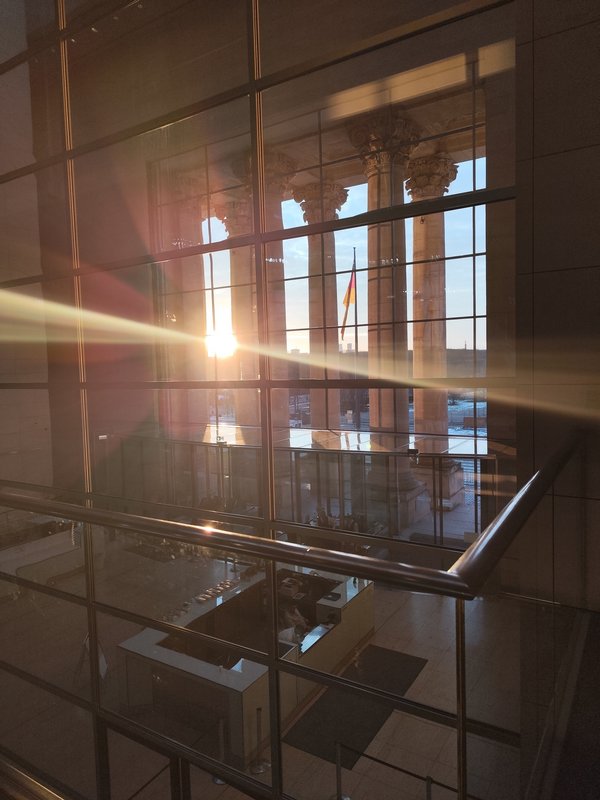 SStimmungsvolles Licht im Deutschen Bundestag. Im Hintergrund eine Deutschlandfahne